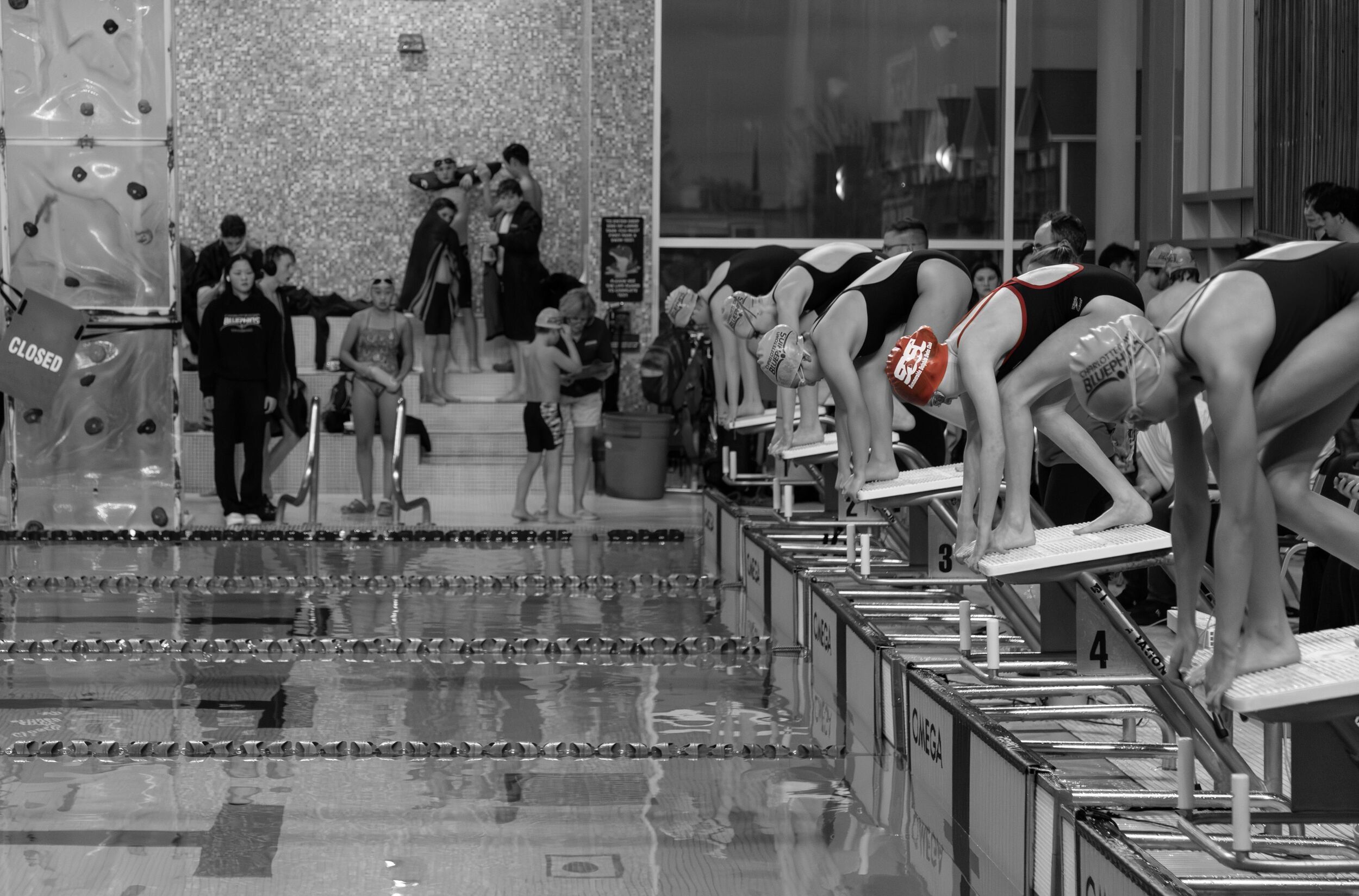 Group of young swimmers on deck wearing SDSC t-shirts and swim caps.