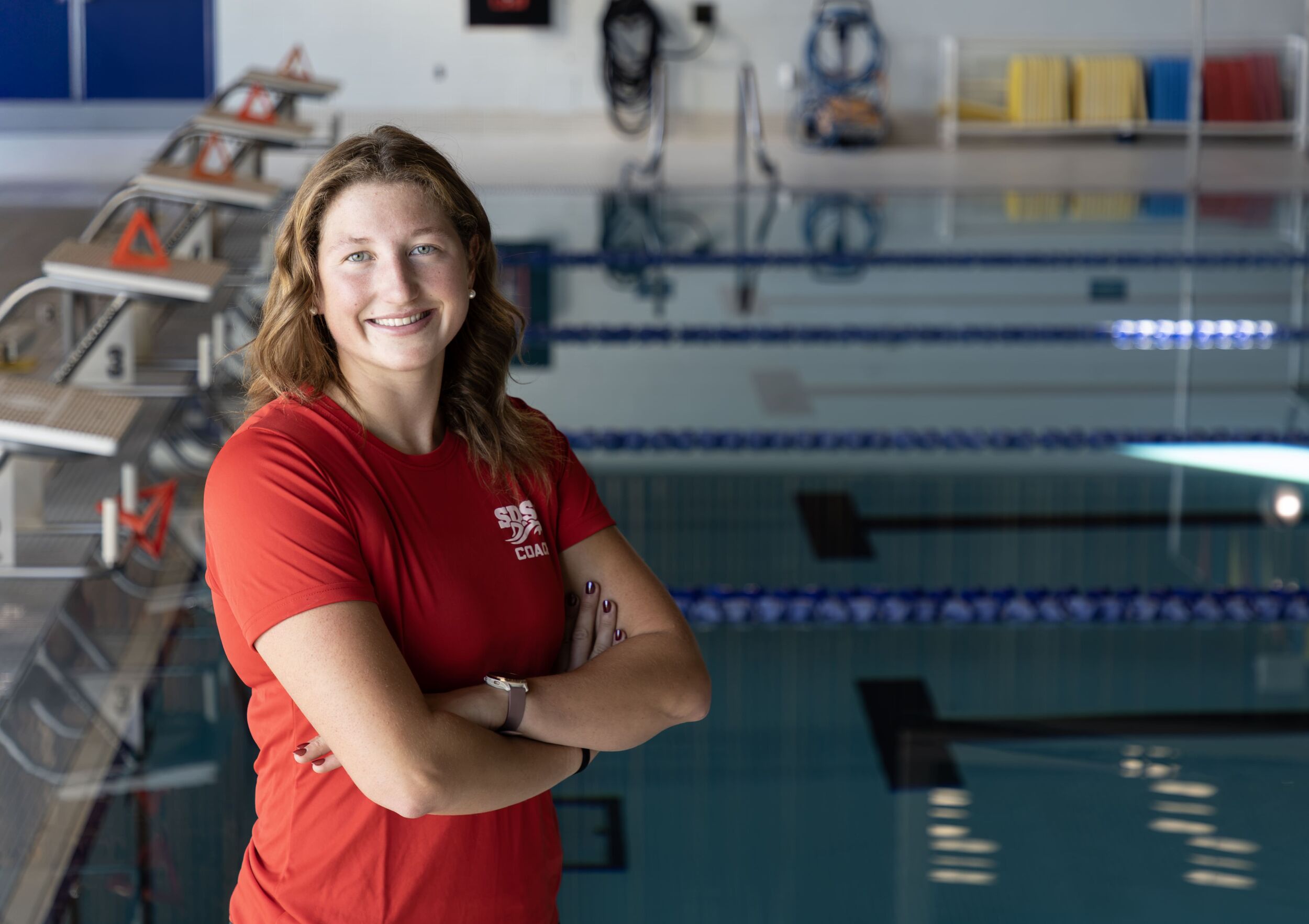 Headshot of Lauren Foland, Assistant Coach with pool in background