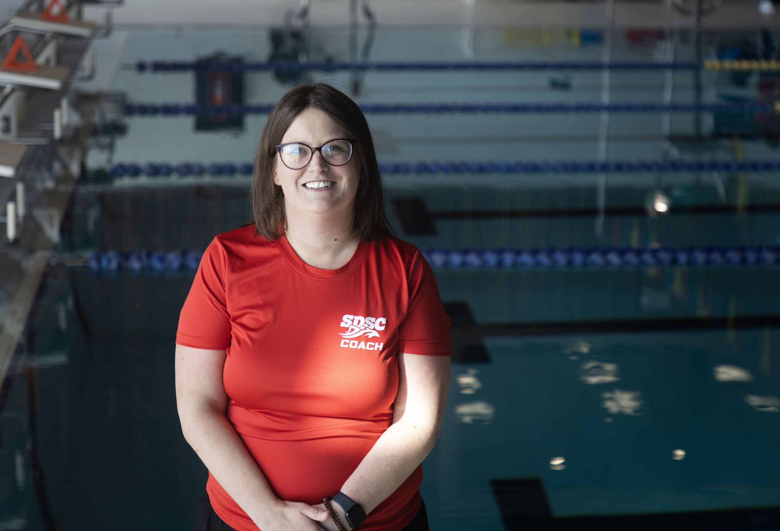 Headshot of Kate Blacquiere, Assistant Coach with pool in background